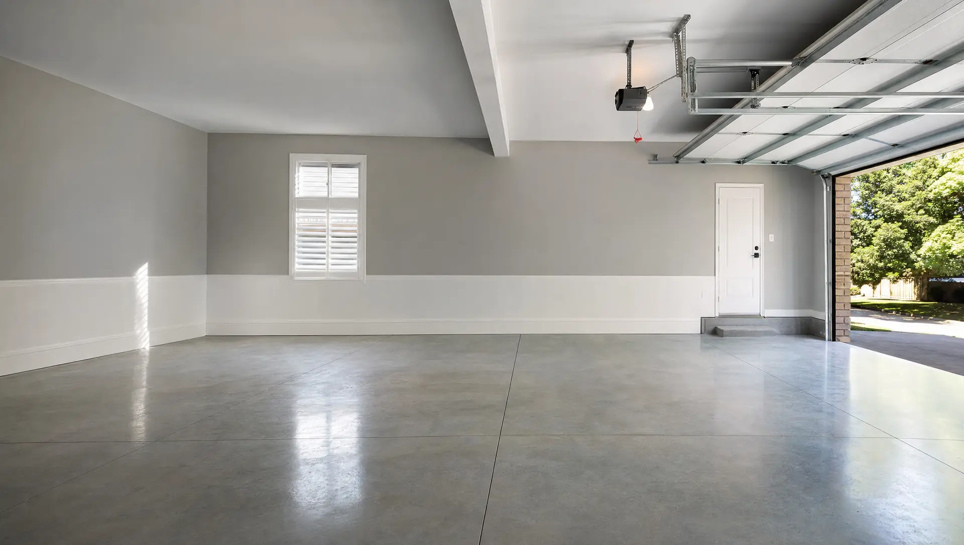 A tidy, empty residential garage with a clean floor and natural light
